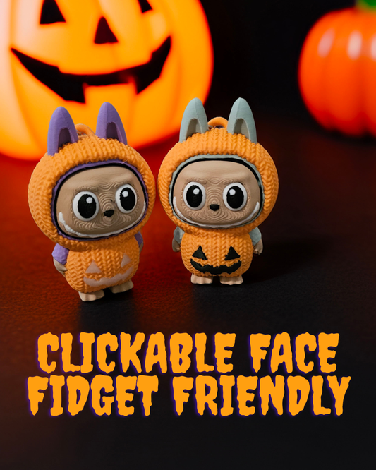 Limited edition Halloween Labubu fidget toy in a pumpkin onesie outfit with jack-o’-lantern details. Cute collectible figure with a clicky face feature, designed for Halloween season décor, stress relief, and toy collectors.