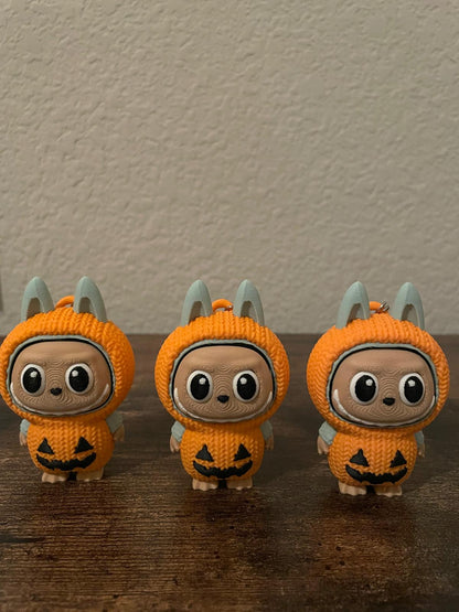 Limited edition Halloween Labubu fidget toy in a pumpkin onesie outfit with jack-o’-lantern details. Cute collectible figure with a clicky face feature, designed for Halloween season décor, stress relief, and toy collectors.