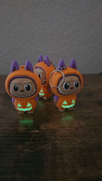 Limited edition Halloween Labubu fidget toy in a pumpkin onesie outfit with jack-o’-lantern details. Cute collectible figure with a clicky face feature, designed for Halloween season décor, stress relief, and toy collectors.