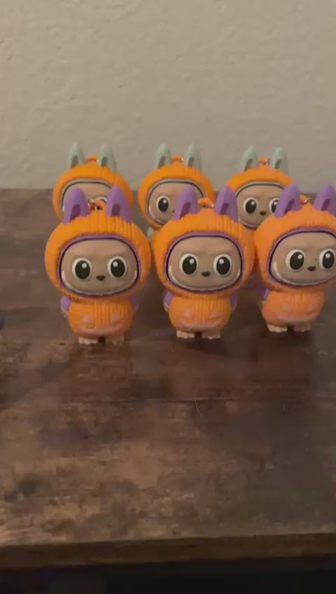 Limited edition Halloween Labubu fidget toy in a pumpkin onesie outfit with jack-o’-lantern details. Cute collectible figure with a clicky face feature, designed for Halloween season décor, stress relief, and toy collectors.